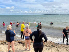 People in and by the sea learning how to use and throw torpedo buoys 